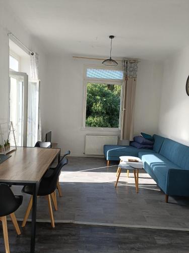 un salon avec un canapé bleu et une table dans l'établissement T3 terrasse calme Nîmes proche centre, à Nîmes