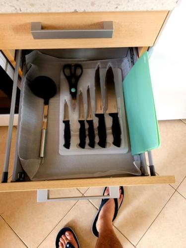 a person is standing in a drawer with knives at Traumhafte Maisonette in Possidi am Strand in Possidi