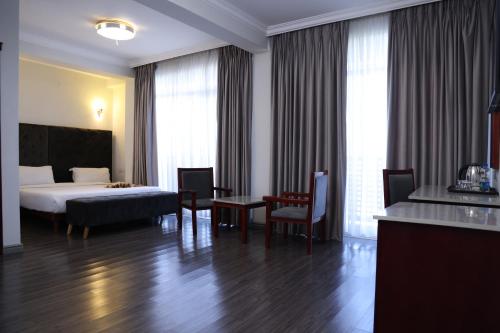 pokój hotelowy z łóżkiem, stołem i krzesłami w obiekcie Trinity Hotel w Addis Abebie