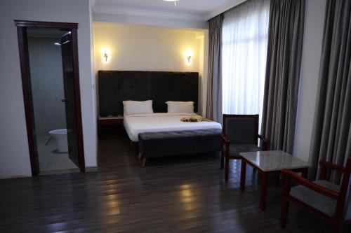 a hotel room with a bed and a chair at Trinity Hotel in Addis Ababa