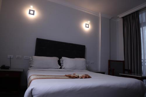 a bedroom with a bed with a stuffed animal on it at Trinity Hotel in Addis Ababa