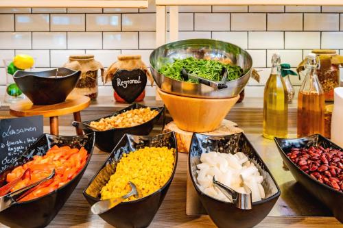 a table topped with bowls of different types of food at AHORN Hotel Am Fichtelberg in Kurort Oberwiesenthal