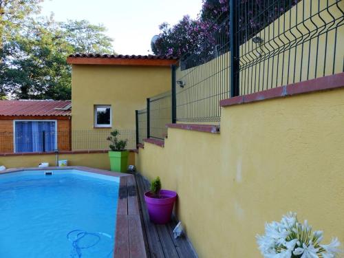 - une piscine à côté d'une maison avec une clôture dans l'établissement Chez Margaux, à Grazac