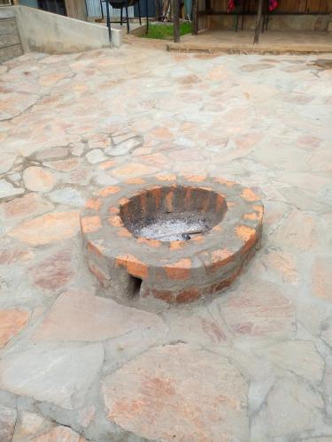 a brick fire pit on a stone patio at Esam Homestay in Sekenani