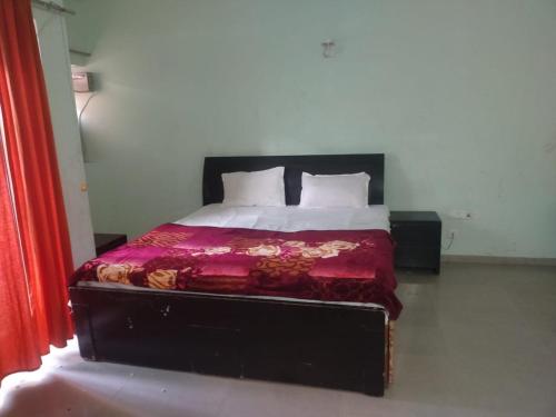Un dormitorio con una cama con un edredón rojo. en Meera 1 bhk Palace Omaxe, en Vrindāvan