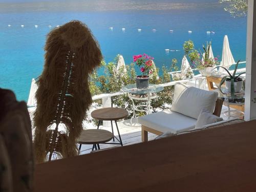 a woman with long hair sitting on a balcony overlooking the ocean at Club Çapa Hotel in Kas