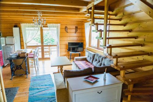 salon ze schodami w drewnianym domku w obiekcie Domek pod lasem w mieście Mizerna