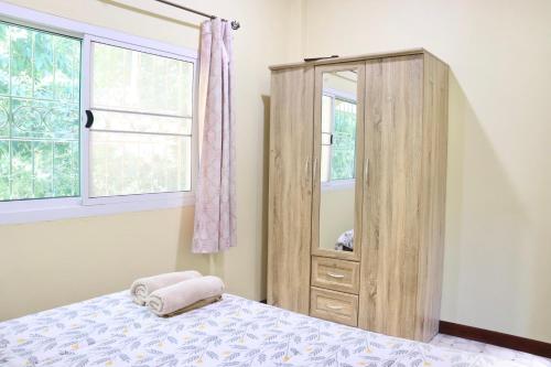 1 dormitorio con armario de madera y cama en Baanrimklong bungalow, en Ko Chang