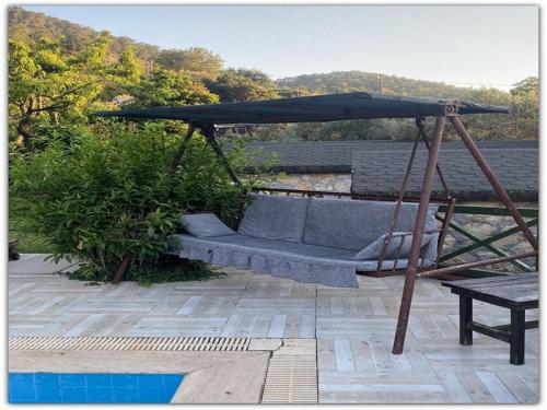 a couch under an umbrella on a patio at Montenegro Motel in Faralya