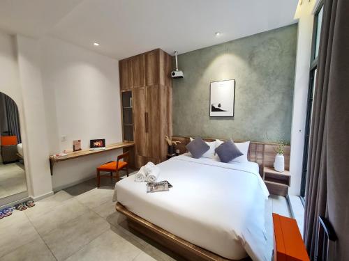 1 dormitorio con 1 cama blanca grande y escritorio en Kin Wander Tan Quy en Ho Chi Minh