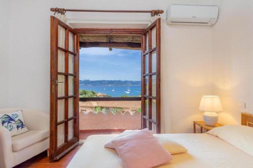 1 dormitorio con puerta que da a un balcón en Sea View Mucchi Bianchi, en Baja Sardinia