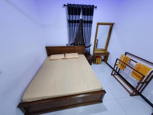 a bedroom with a bed and a mirror in it at Nilaveli Guest House in Nilaveli