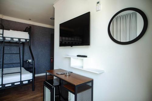 a room with a tv and a desk and bunk beds at Belsun Hotel in Beldibi