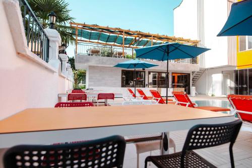 a table and chairs with blue umbrellas on a patio at Belsun Hotel in Beldibi