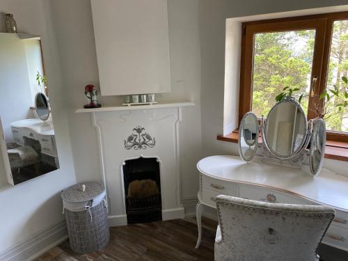 Habitación con espejo, escritorio y chimenea. en Coastal Escape: 4 bed mansion, en Port Talbot