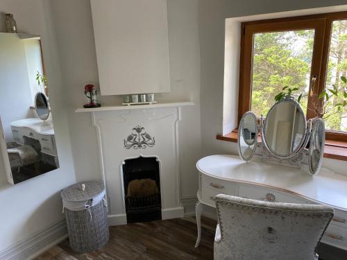 a room with a mirror and a desk and a fireplace at Coastal Escape: 4 bed mansion in Port Talbot