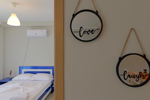 a bedroom with a bed and two mirrors on the wall at Llamani Apartments in Himare