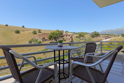 a table and chairs on a balcony with a view at Llamani Apartments in Himare
