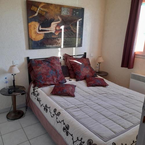 une chambre avec un grand lit avec des oreillers rouges dans l'établissement Jolie Marina, au Barcarès