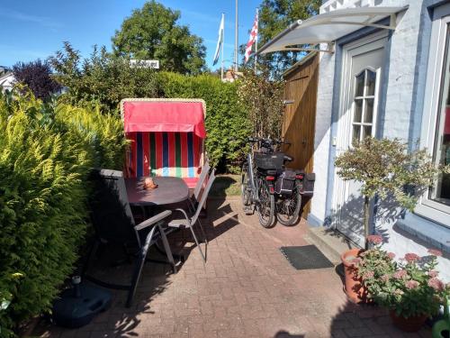 a patio with a table with a red cover and a bike at FeWo 8 im 1Stock, Terrasse mit Strandkorb in Dahme