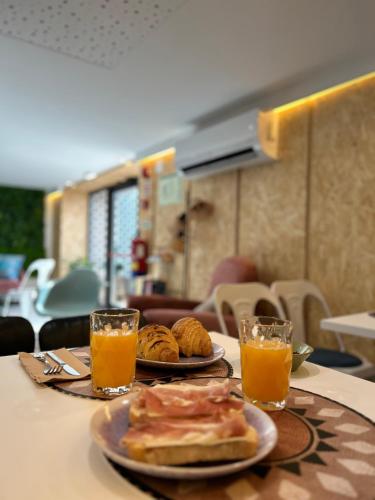a table with two plates of food and two glasses of orange juice at Alma Candida 11 in Valença