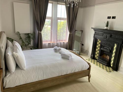a bedroom with a large bed with towels on it at Coastal Escape: 4 bed mansion in Port Talbot