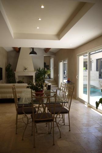 une salle à manger avec une table et des chaises en verre dans l'établissement Le Paladori, à Foissac