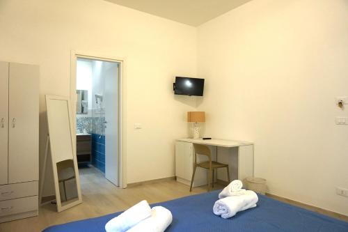 Camera con letto, scrivania e TV. di La Scala del Moro Rooms - Dolce Risveglio a Lampedusa