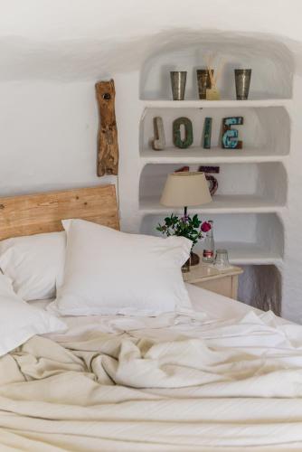 a bedroom with a white bed and a table with a lamp at Can Quince Balafia Ibiza Hotel - Turismo de Interior in Sant Llorenç de Balafia