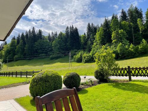 a wooden bench sitting in a yard with bushes and trees at Frieda's Platzl in Abtenau