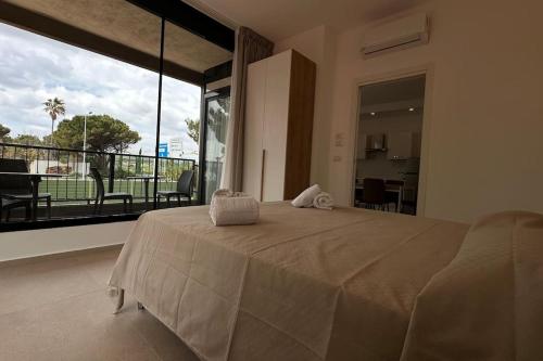 a bedroom with a large bed and a large window at CconfortHotels Puglia Promenade Apartment 4 in Bari