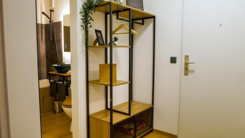 a bathroom with a wooden shelf in a room at Gemütliches Apartment im Zentrum von Neu Ulm in Neu Ulm