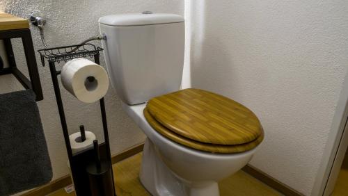 a toilet with a wooden seat and a roll of toilet paper at Gemütliches Apartment im Zentrum von Neu Ulm in Neu Ulm