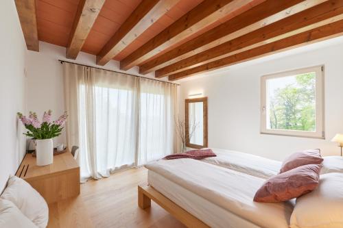 um quarto com uma cama e uma grande janela em CasaMartini Bed & Breakfast em Fonte