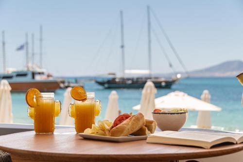 un tavolo con un piatto di cibo e un libro aperto di Cactus suite ad Agia Anna Naxos