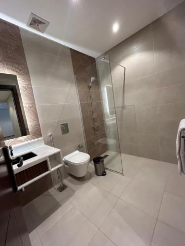 a bathroom with a shower and a toilet and a sink at نمو الديار in Al ‘Azīzīyah