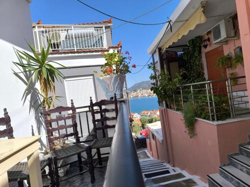 balkon w budynku z krzesłami i widokiem na ocean w obiekcie Robert House w mieście Samos