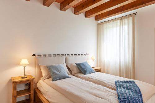 um quarto com uma grande cama branca e 2 candeeiros em CasaMartini Bed & Breakfast em Fonte