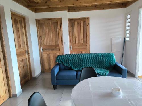 a living room with a blue couch and a table at Résidence Corail in Sainte-Rose