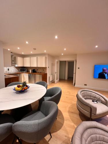 倫敦的住宿－Mayfair Piccadilly Apartment 5，客厅配有桌椅和电视。