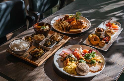 a wooden table with plates of food on it at Hotel Resol Trinity Naha in Naha