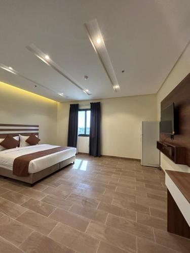 um quarto grande com uma cama e uma televisão em نمو الديار em Al ‘Azīzīyah