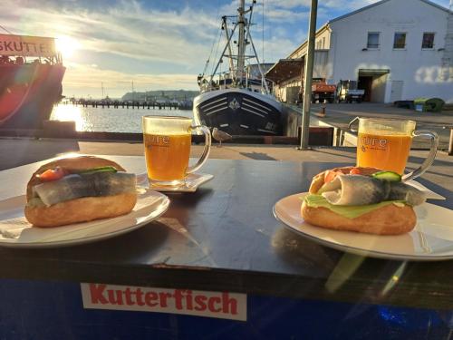 dos sándwiches en platos en una mesa con dos vasos de cerveza en Ferienhaus Sachsenblick, en Sassnitz