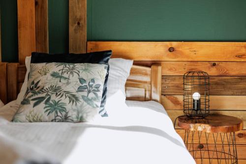 a bed with a pillow and a green wall at Jesteśmy Na Ty - Apartamenty in Lewin Kłodzki