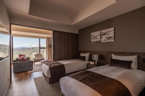 留寿都村にあるThe Vale Rusutsuのベッド2台とバルコニーが備わるホテルルームです。