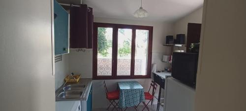 een keuken met een wastafel, een tafel en een raam bij VILLA Le MARVIVO in La Seyne-sur-Mer