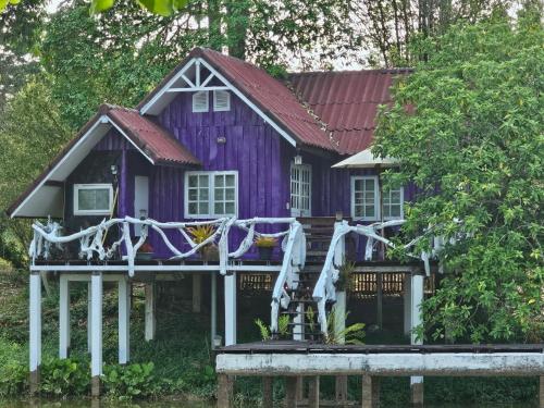 a purple house with a porch at ไอหมอก ชาเล่ต์ in Wang Nam Khieo