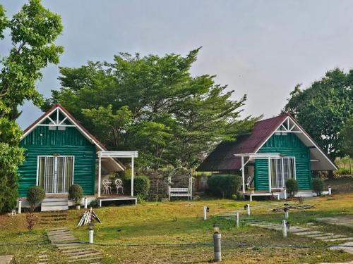 a green house with a red roof at ไอหมอก ชาเล่ต์ in Wang Nam Khieo