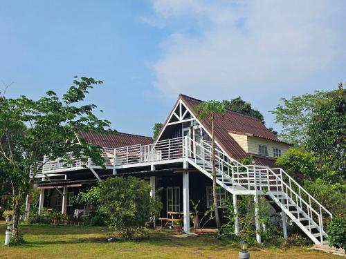 a house with a staircase on the side of it at ไอหมอก ชาเล่ต์ in Wang Nam Khieo