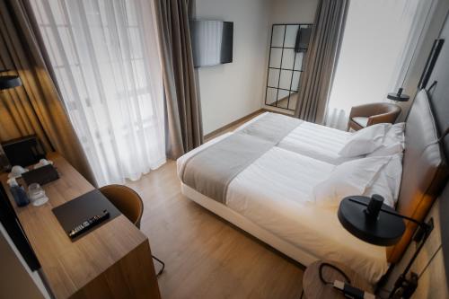 a hotel room with a bed and a desk with a laptop at Hotel & Spa Convento San Francisco in Soria
